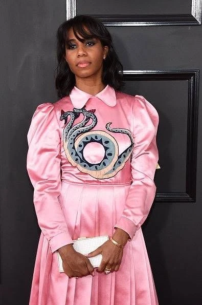 Santigold in a pink dress on the Grammys red carpet holding a CuteCircuit Mirror Handbag