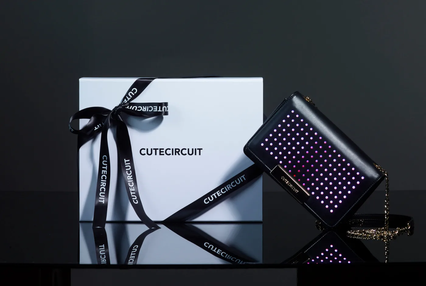 CuteCircuit illuminated leather handbag displayed beside its branded gift box